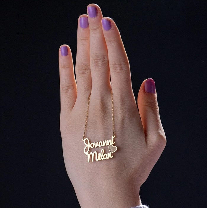 Hand wearing a gold necklace with 'Jovanni Milan' on a black background